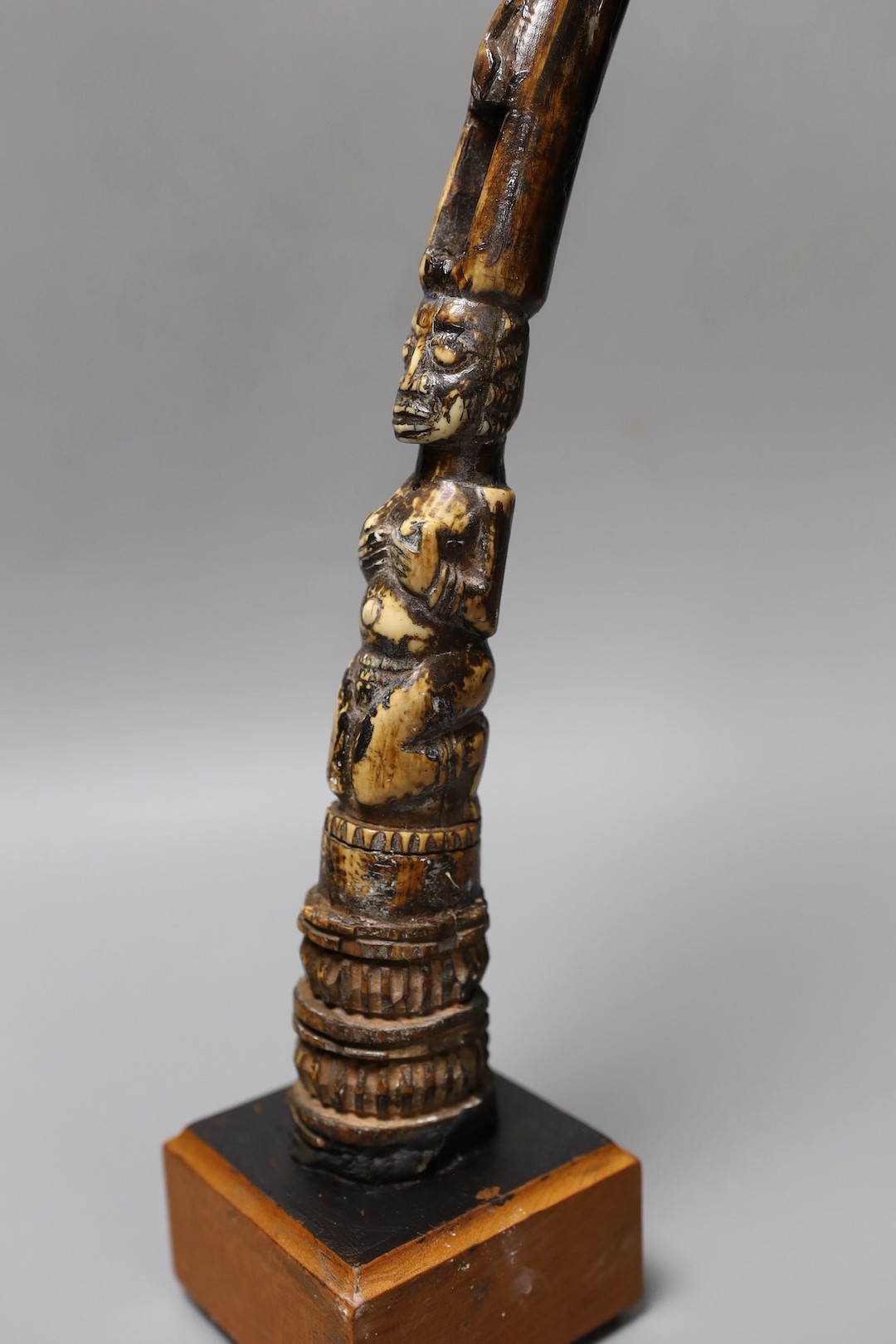 An African carved ivory divination tapper, probably Yoruba tribe on stand, 35 cms high.